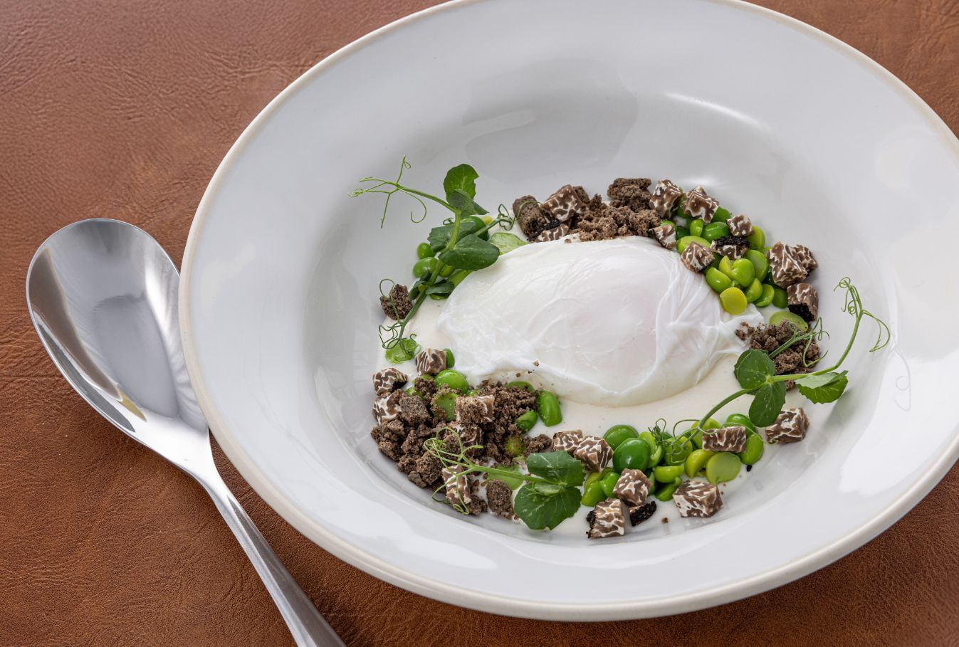Piatto con cereali, piselli e crema bianca
