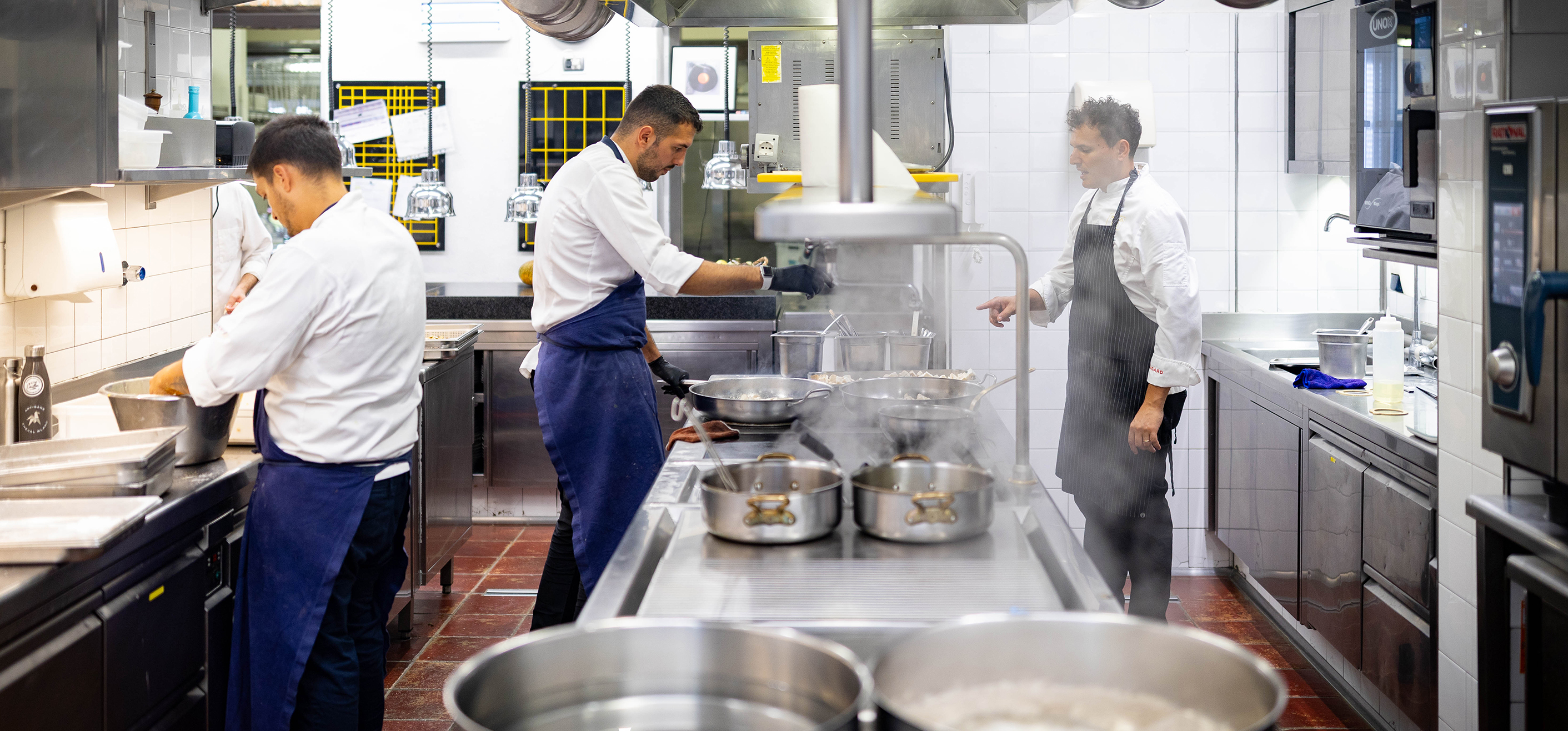 Brigata di cucina al lavoro ai fornelli
