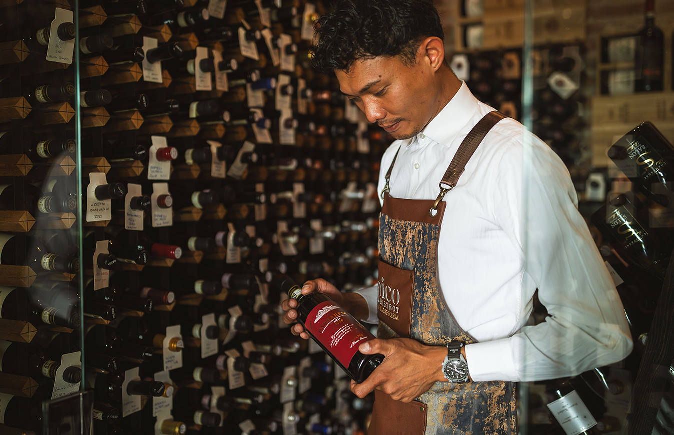 Sommelier in cantina con una bottiglia di vino rosso